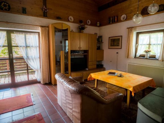 Wohnbereich mit Esstisch und Zugang zum Balkon